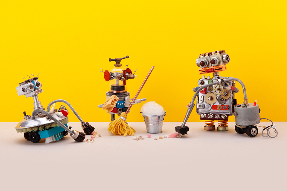 tre söta robotar städar mot gul bakgrund.jpg